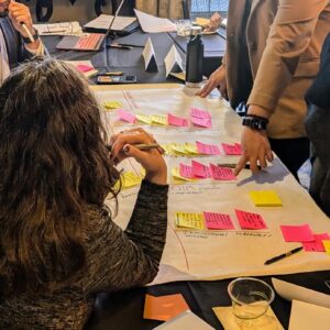 Conference participants working together around a table with post-it notes